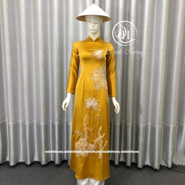 &Aacute;o d&agrave;i thời trang Đinh Hương lụa hai da v&agrave;ng đồng 2 t&agrave; đ&iacute;nh kết họa tiết sen trắng